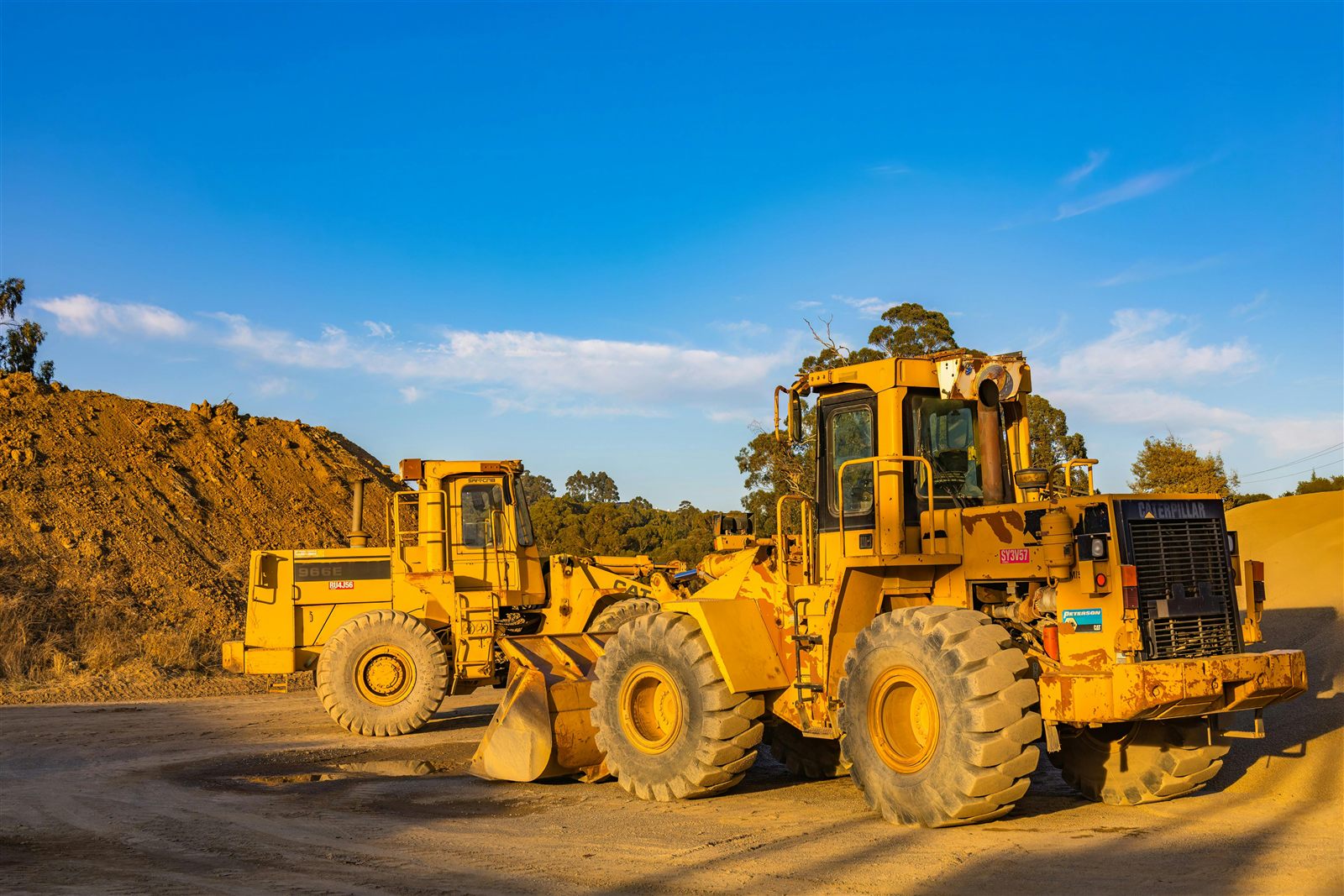 Cargadoras frontales de minería estacionadas en zona de movimiento de suelos al atardecer