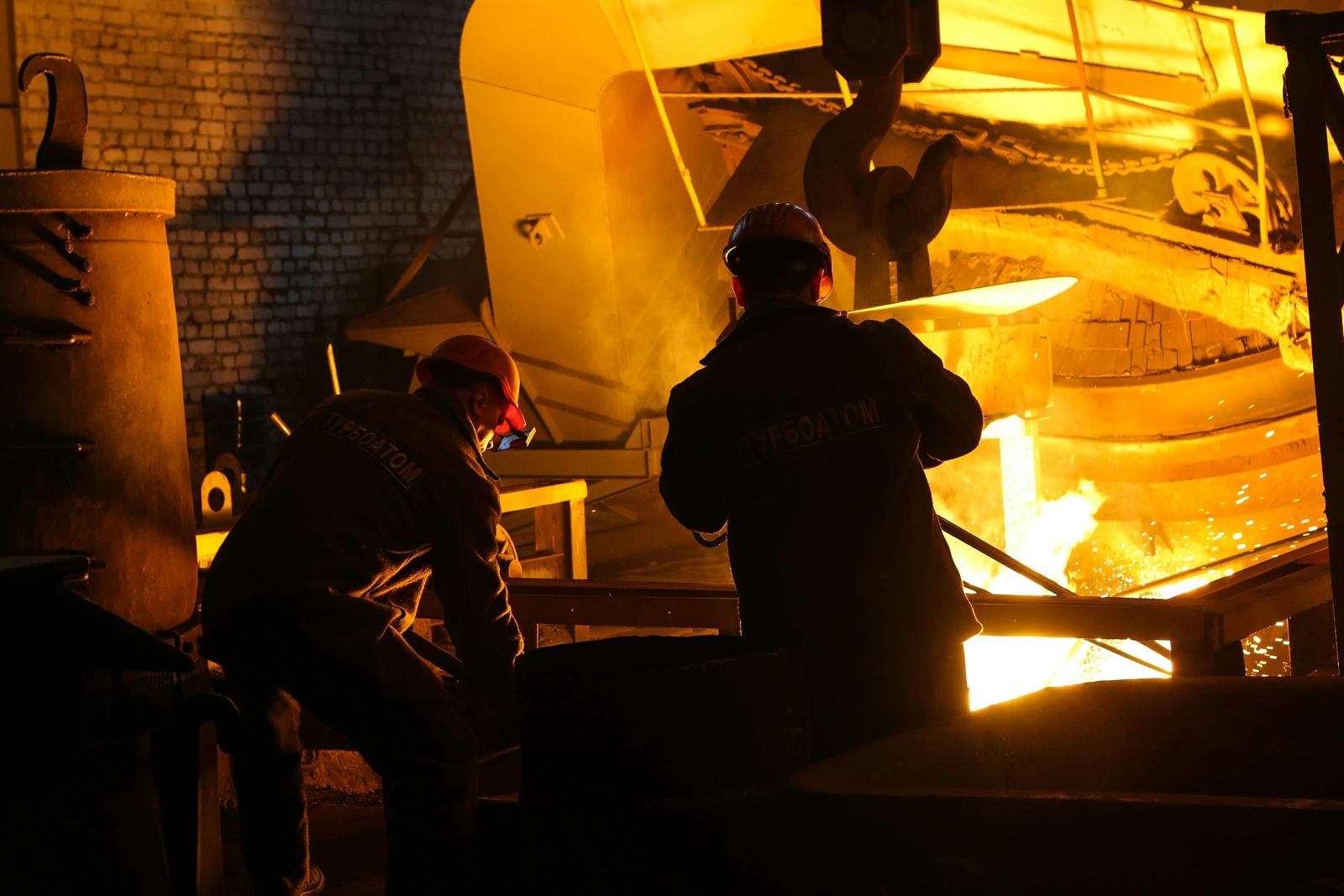 Operarios en acería durante una colada de acero fundido, control de energía térmica peligrosa