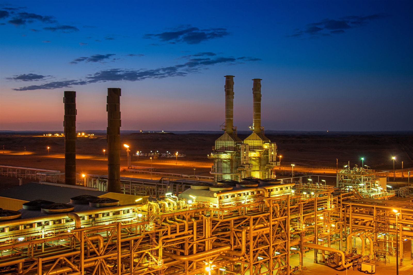 Complejo industrial de oil and gas y petroquímica iluminado al atardecer, infraestructura de heavy industry