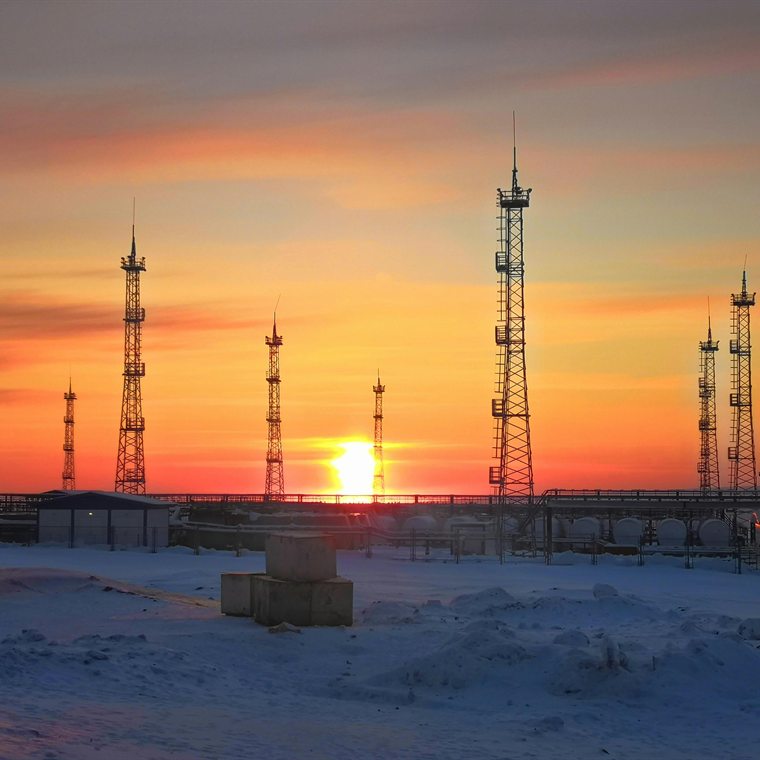 Yacimiento de oil and gas en sitio remoto y nevado al atardecer, infraestructura de operación crítica